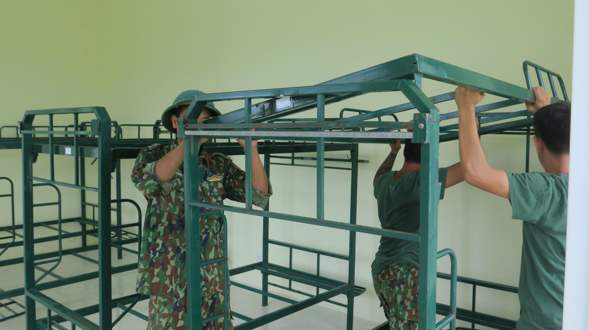 Lực lượng quân đội lắp đặt giường chuẩn bị đón người về cách ly tập trung tại Trung tâm Giáo dục quốc phòng An ninh (ảnh Phan Sáu)