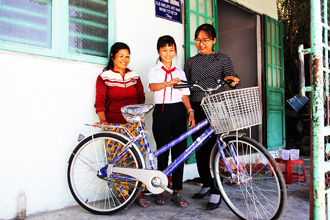 Niềm vui của chị Nhi và mẹ con bà Phê khi con bà được hỗ trợ xe đạp.