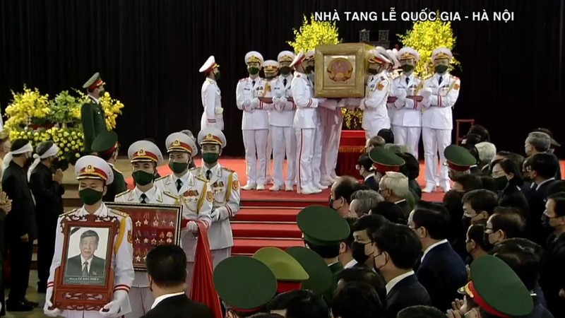 Các sĩ quan QĐND Việt Nam đang rước di ảnh, khung gắn Huân chương, Huy chương của Nguyên Tổng Bí thư Lê Khả Phiêu cùng lá Quốc kỳ di chuyển ra linh xa.