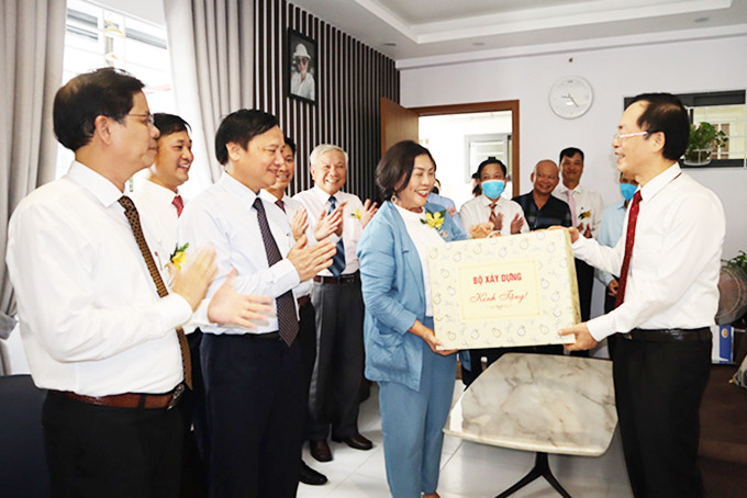 Lãnh đạo Bộ Xây dựng và lãnh đạo tỉnh tặng quà cho một gia đình chính sách trong dự án Nhà ở xã hội.