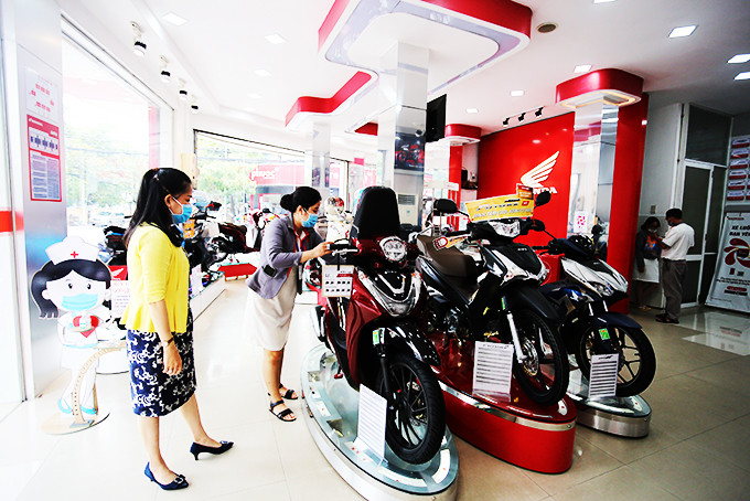 Nhân viên bán hàng  giới thiệu  các dòng xe cho khách tại cửa hàng Honda Huy Tân.  