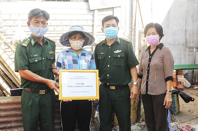Đồn Biên phòng Cam Ranh trao 10 bao xi măng và 1 xe cát  cho gia đình chị Hoa.