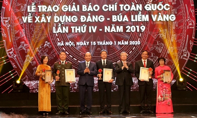 Thủ tướng Nguyễn Xuân Phúc và đồng chí Trần Quốc Vương, Ủy viên Bộ Chính trị, Thường trực Ban Bí thư trao giải A cho các tác giả đạt giải Báo chí quốc gia về Xây dựng Đảng (Búa liềm vàng) năm 2019. 