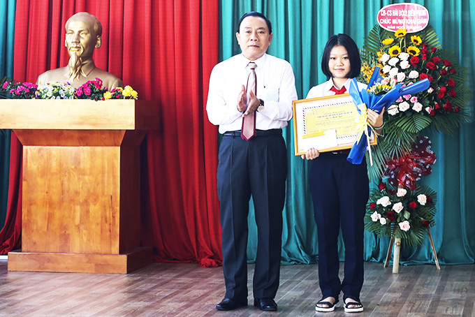 Lãnh đạo Sở Thông tin và Truyền thông thay mặt Ban tổ chức cuộc thi viết thư quốc tế UPU trao giải cho em Lê Thanh Ngân.  