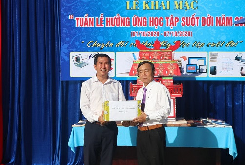Đại diện Thư viện tỉnh Khánh Hòa (bìa trái) trao tặng một số đầu sách cho Trường THCS Cao Bá Quát. 