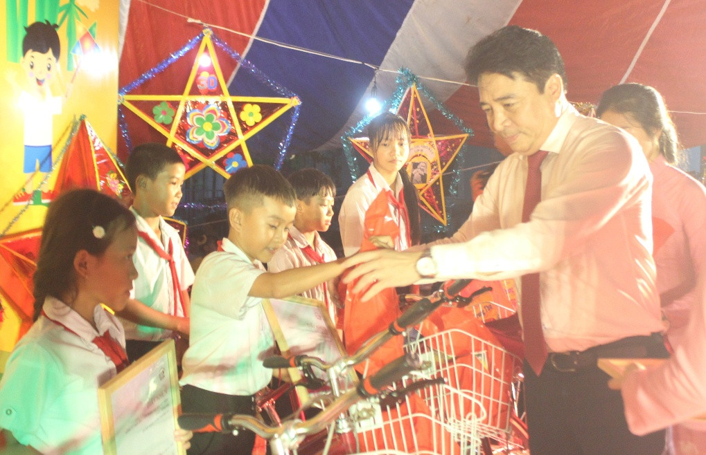 Ông Nguyễn Khắc Toàn trao quà cho trẻ em vượt khó học giỏi.