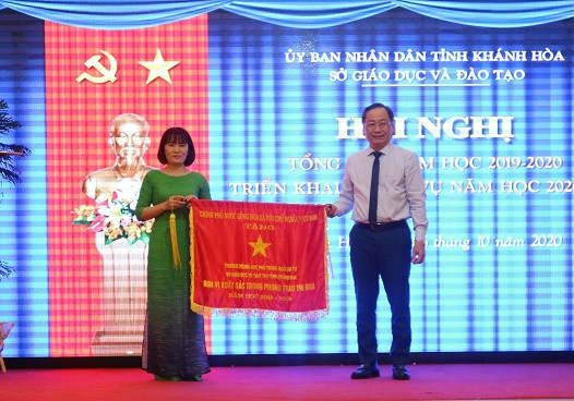 Ông Nguyễn Đắc Tài trao cờ thi đua của Chính phủ cho Trường THPT Ngô Gia Tự. 