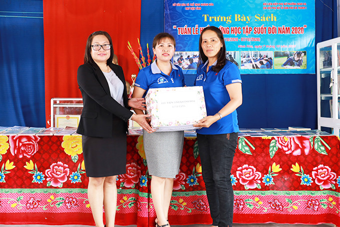 Lãnh đạo Thư viện tỉnh (bên trái) trao sách cho đại diện  Chi hội Phụ nữ tổ dân phố Hà Thanh 1.