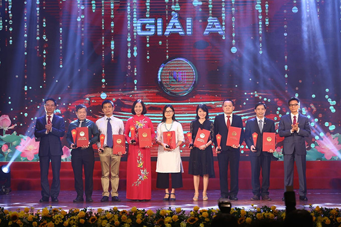 Phó Thủ tướng Vũ Đức Đam và Bộ trưởng Bộ Thông tin và Truyền thông Nguyễn Mạnh Hùng trao giải A cho tác giả, nhóm tác giả đoạt giải. Ảnh: Minh Quyết - TTXVN