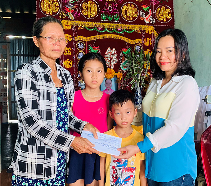 Bà Thái Thị Lệ Hằng - Phó Tổng Biên tập Báo Khánh Hòa trao tiền ủng hộ cho gia đình hai cháu bé mồ côi cha mẹ
