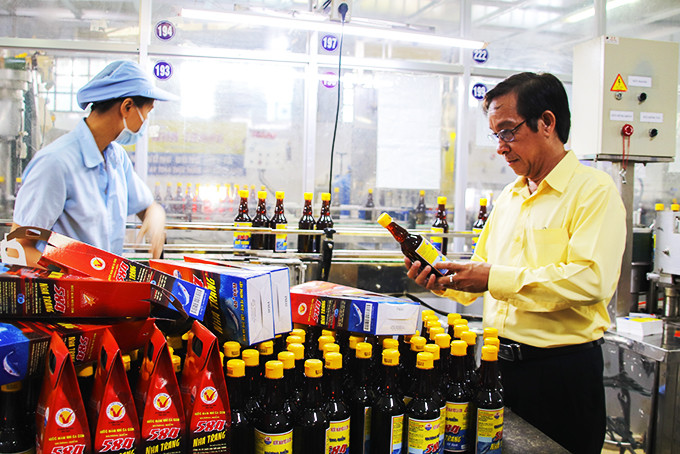 Ông Huỳnh Ngọc Diệp kiểm tra các sản phẩm nước mắm vừa đóng chai.