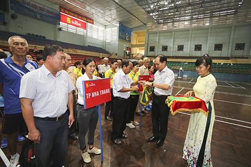 Nguyen Tuan Thanh—deputy director of Khanh Hoa Province’s Department of Culture and Sports, head of the organizing committee—giving souvenir flags to teams