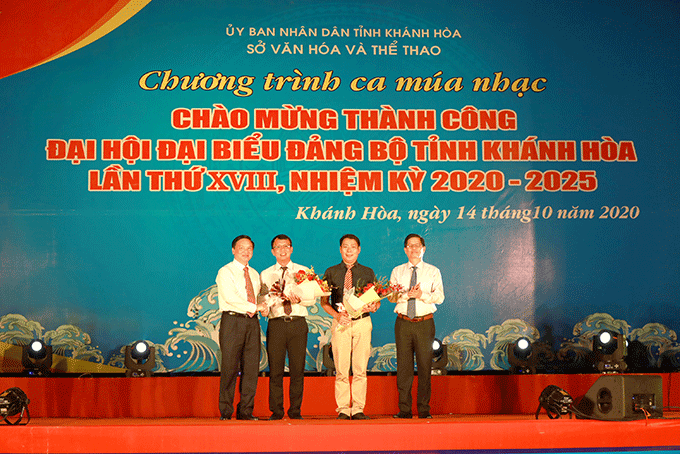 Ông Nguyễn Khắc Định (bên trái) và ông Nguyễn Tấn Tuân (bên phải) tặng hoa chúc mừng đơn vị tổ chức chương trình nghệ thuật.