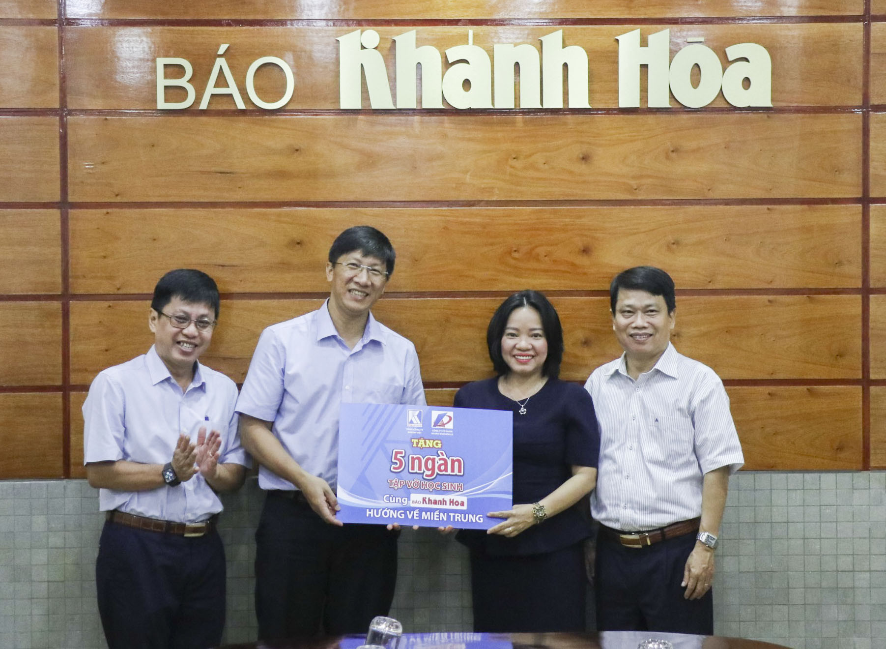 Đại diện Tổng Công ty Khánh Việt (bìa trái) trao tượng trưng 5.000 cuốn vở cho lãnh đạo Báo Khánh Hòa.