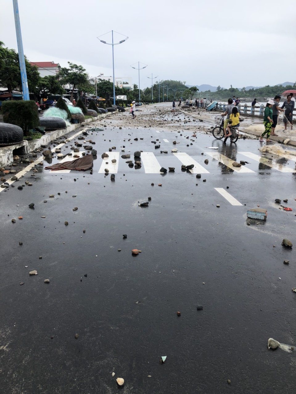 Một lượng lớn đất đá bị sóng cuốn dội lên mặt đường Phạm Văn Đồng.