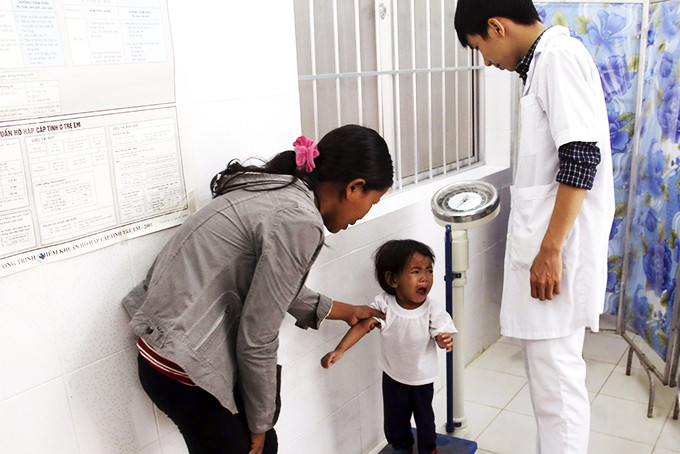 Cân đo cho trẻ tại cơ sở y tế huyện Khánh Vĩnh. 