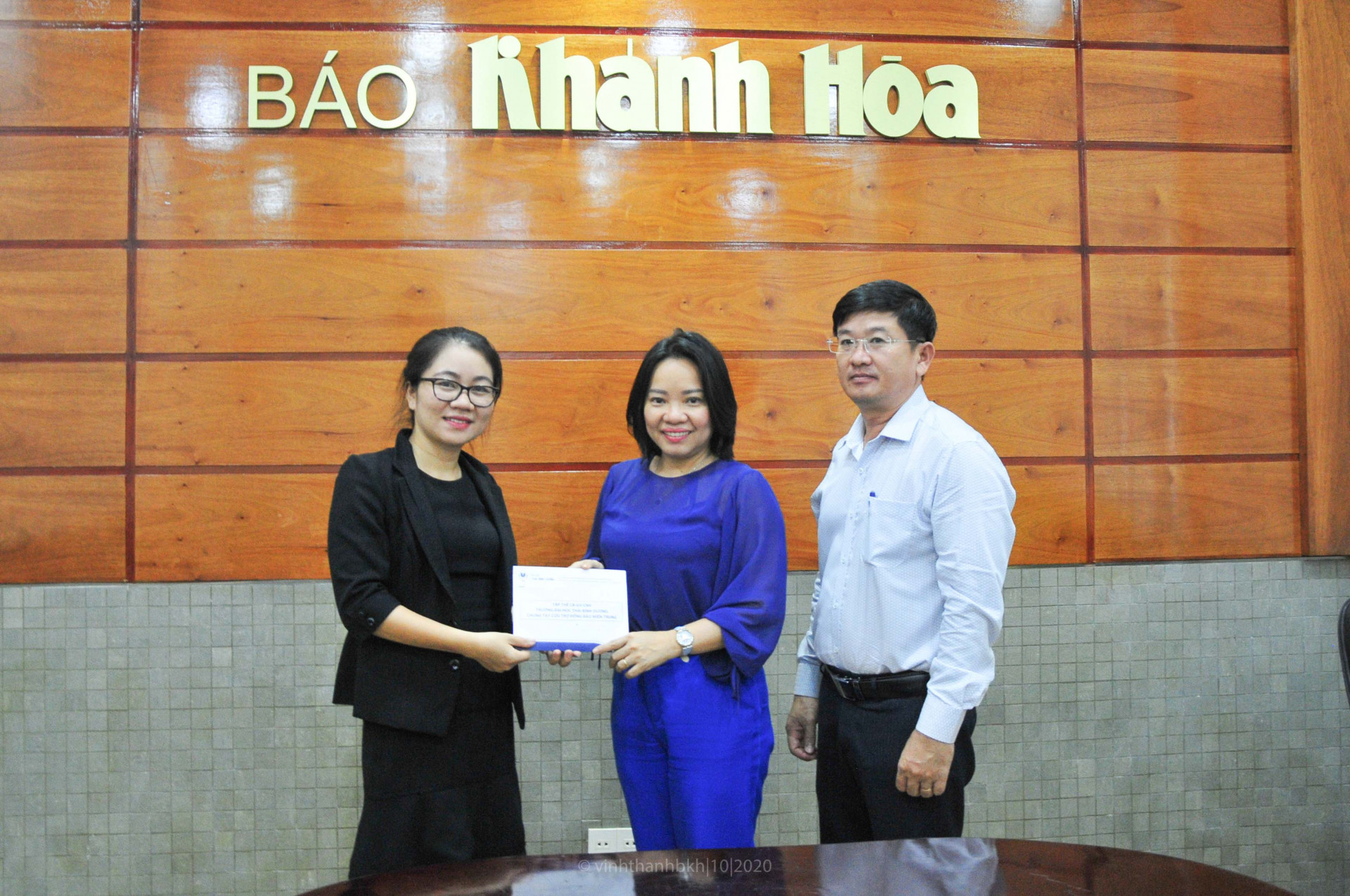 Đại diện Trường Đại học Thái Bình Dương (bìa trái) trao số tiền ủng hộ người dân các tỉnh miền Trung cho lãnh đạo Báo Khánh Hoà