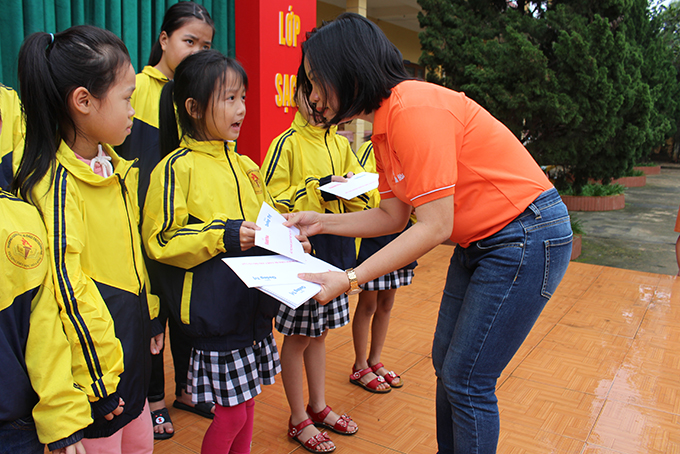Thai Thi Le Hang presenting support to pupils of Hoa Binh Primary School