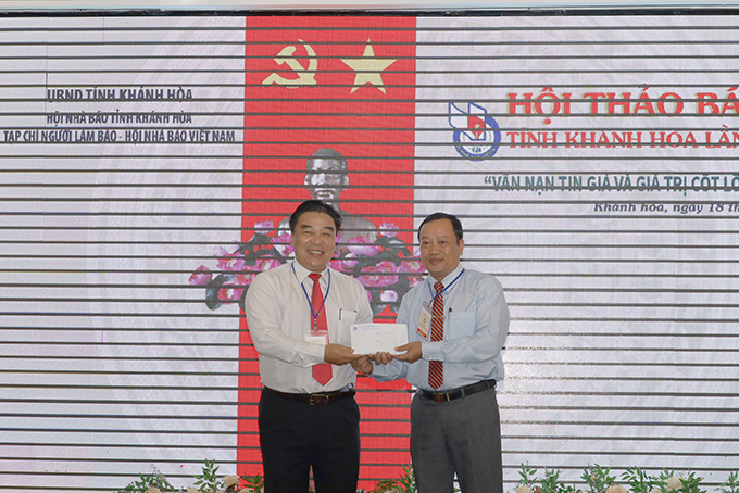 Đại diện Ban tổ chức hội thảo (bên trái) trao số tiền các đại biểu quyên góp ủng hộ đồng bào miền Trung tới đại diện Ủy ban MTTQ Việt Nam tỉnh Khánh Hòa. 