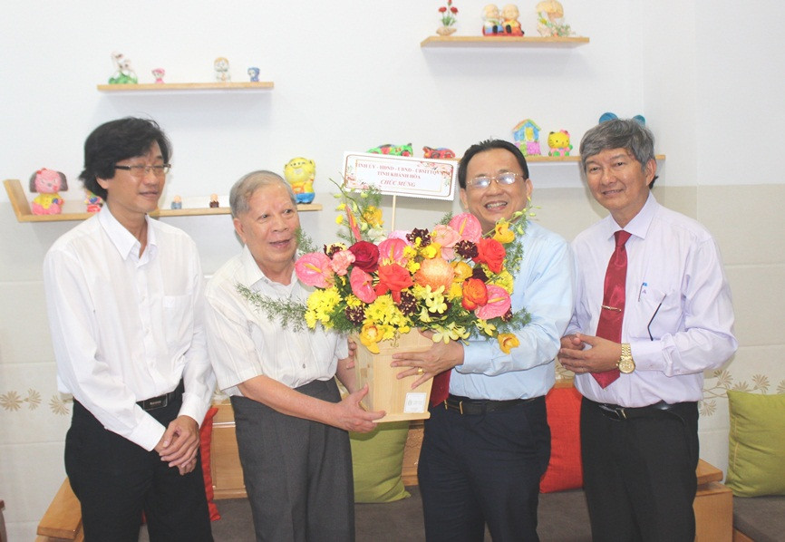 Ông Lê Hữu Hoàng (thứ 2 từ phải qua) tặng hoa chúc mừng Nhà giáo ưu tú Ngô Sanh.
