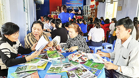 Người dân tổ dân phố Hà Thanh 1 đọc sách từ mô hình Tủ sách nhân ái.  