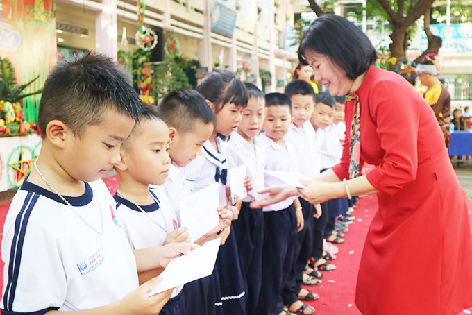 Hiệu trưởng Trường Tiểu học Tân Lập 2 (TP. Nha Trang) trao quà cho học sinh có hoàn cảnh khó khăn. 