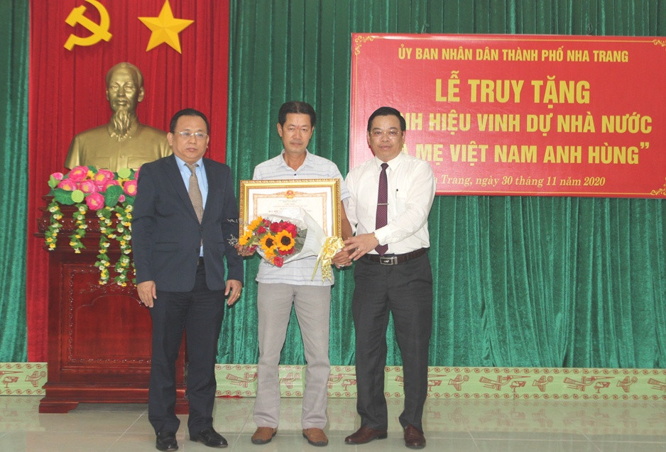Thừa ủy quyền của Chủ tịch nước, ông Lê Hữu Hoàng (bên trái) trao danh hiệu Bà mẹ Việt Nam Anh hùng cho thân nhân mẹ Nguyễn Thị Điển.