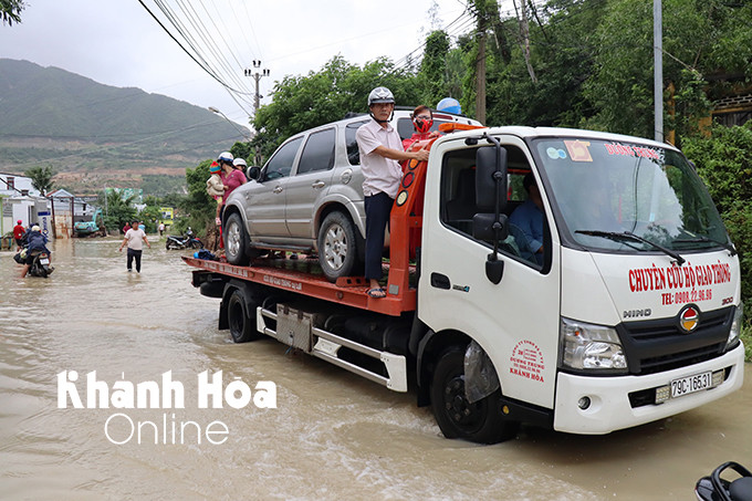Người dân đi ké xe cứu hộ di dời khỏi vùng ngập lụt