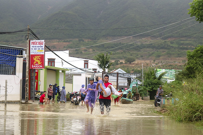 Đưa một người dân ở xã Vĩnh Thái (TP. Nha Trang) qua đoạn ngập đi cấp cứu.