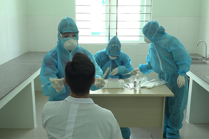 Lấy mẫu xét nghiệm tại Trung tâm kiểm dịch y tế quốc tế tại sân bay Cam Ranh. Ảnh: Mã Phương
