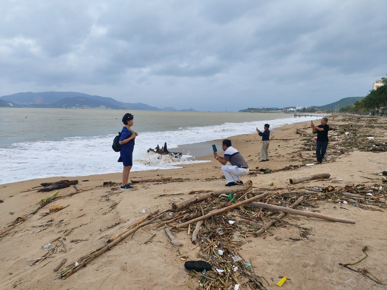 Nhiều du khách dạo chơi trên bãi biển ngập rác.