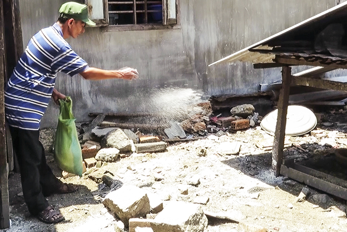 Người dân huyện Diên Khánh rắc vôi bột khử trùng môi trường chăn nuôi.