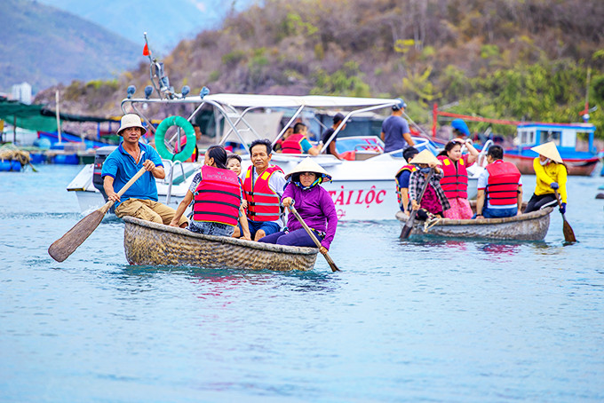 Khách du lịch đi thuyền thúng tham quan  làng chài trên vịnh Nha Trang.