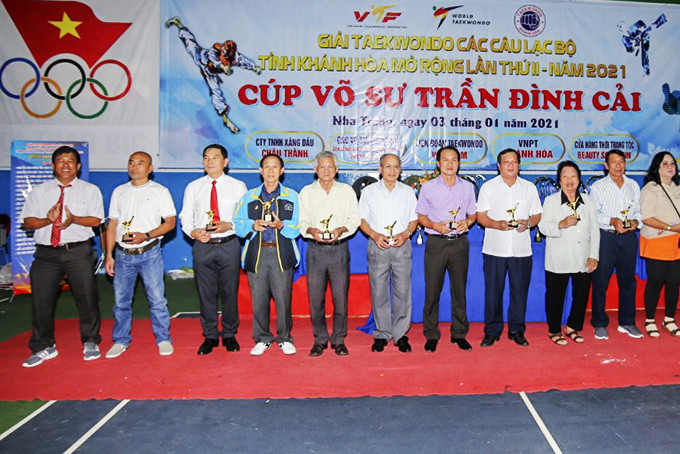 Organizer presents souvenir cups to people contributing to Khanh Hoa’s taekwondo movement.