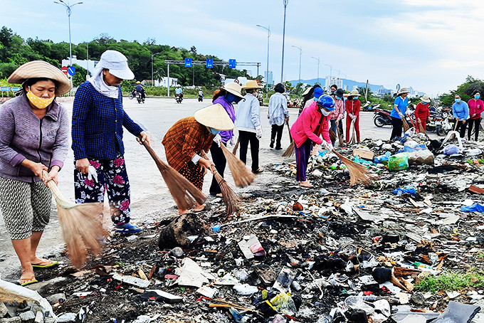 Hội viên, phụ nữ xã Vĩnh Thái dọn vệ sinh môi trường trên đường Võ Nguyên Giáp.