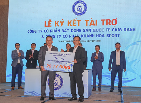 Sponsor's representative Dao Minh Son (right) gives sponsorship cheque of VND20 billion to Nguyen Minh Hieu, the representative of the club’s management unit. 