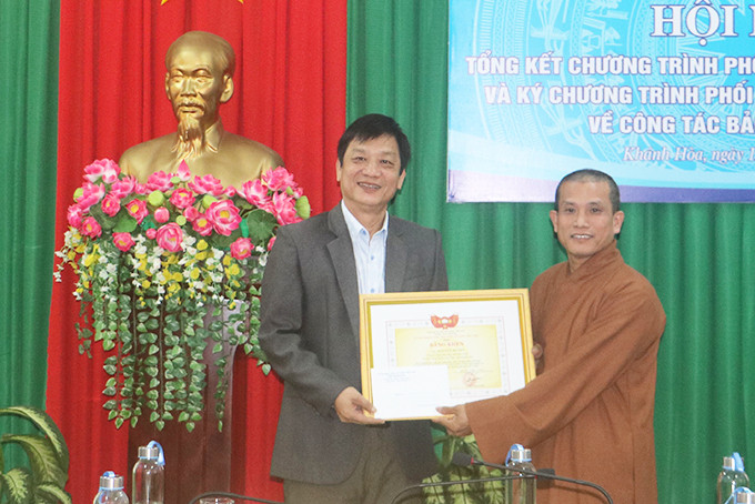 Đồng chí Huỳnh Mộng Giang - Phó Chủ tịch Thường trực  UBMTTQ Việt Nam tỉnh trao bằng khen cho Đại đức Thích Quảng Ân.