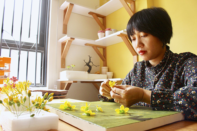 Chị Nguyễn Thị Nhi đang chuẩn bị cho đơn hàng hoa mai làm từ đất sét.