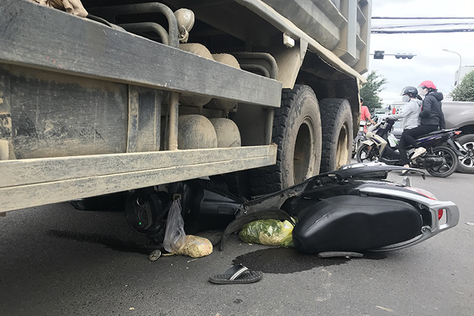 Sau va chạm, chiếc xe máy bị cuốn vào gầm xe tải.