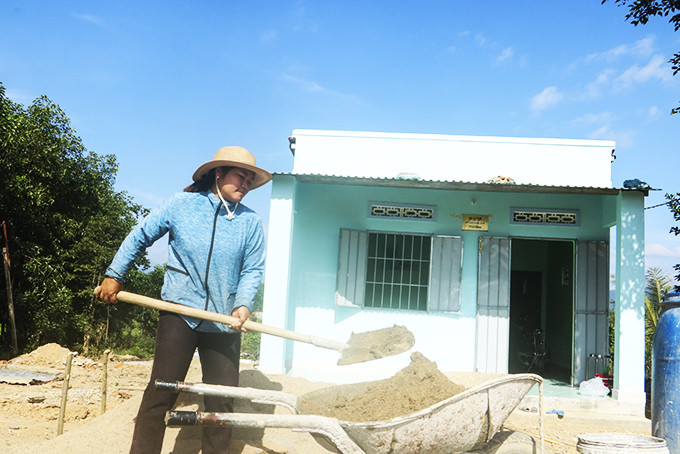 Chị Cao Thị Thu Ngọc đang làm sân cho ngôi nhà mới.