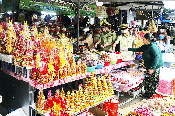 Lực lượng quản lý thị trường kiểm tra mặt hàng bánh, kẹo tại chợ Xóm Mới.