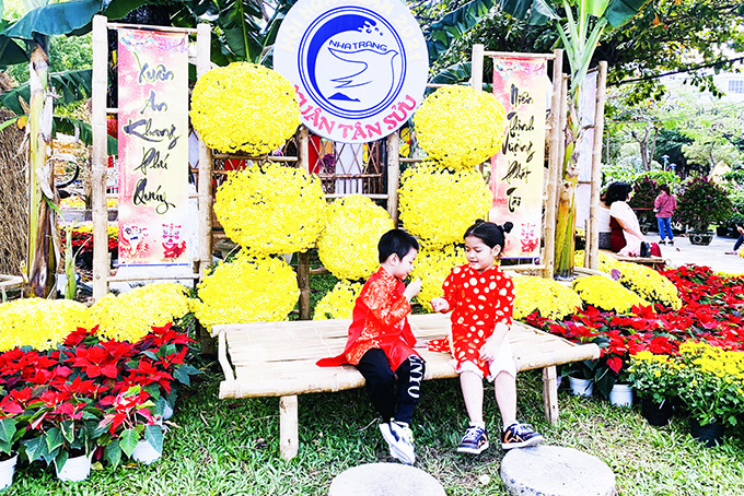 2 em nhỏ chơi oản tù tì tại Hội hoa Xuân Nha Trang.