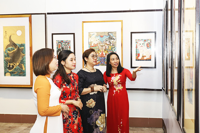 Museum staff introducing folk paintings to visitors