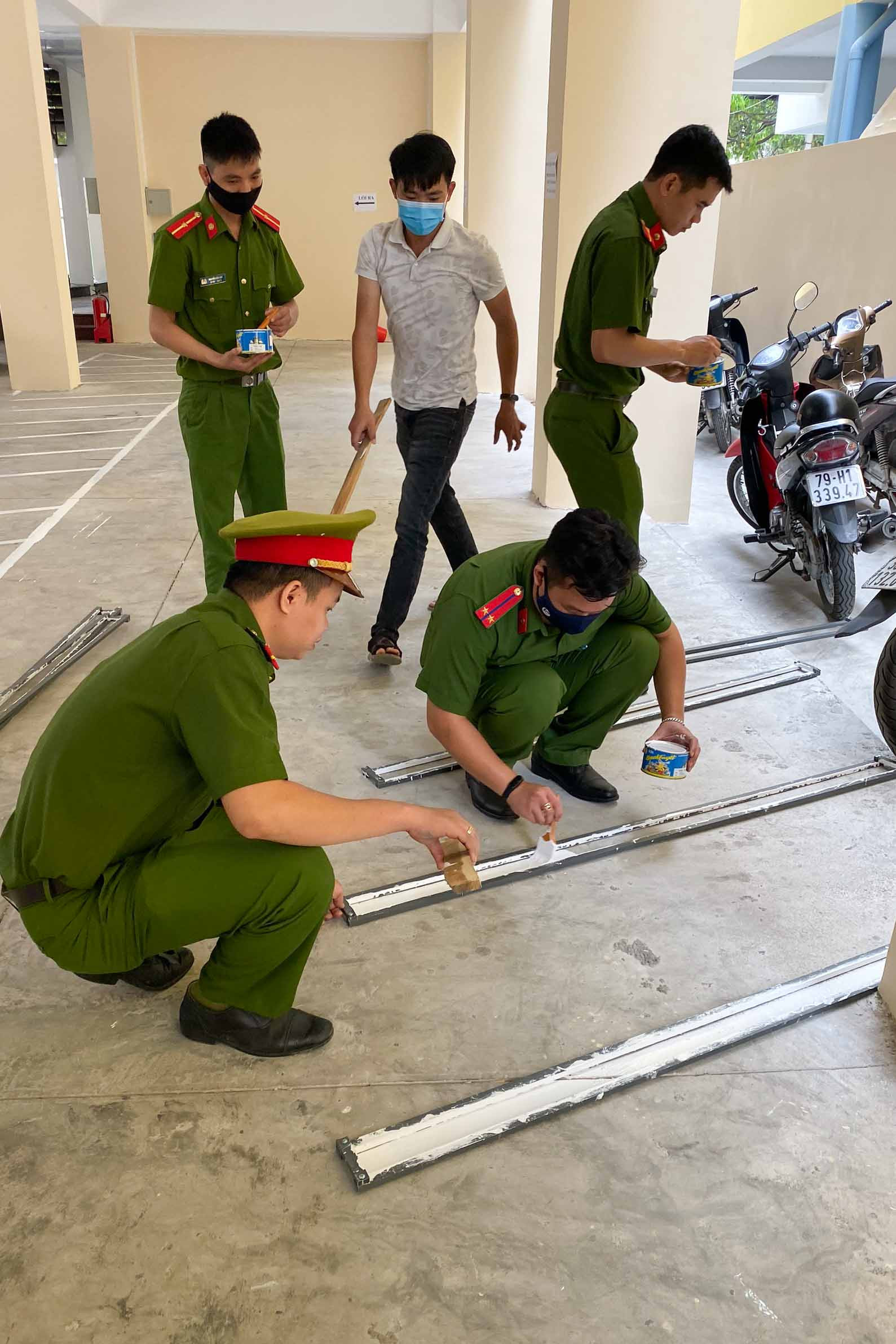 Các đoàn viên, thanh niên thực hiện sơn mới vạch kẻ để xe phục vụ nhân dân, cán bộ đến công tác tại trụ sở Công an TP. Nha Trang