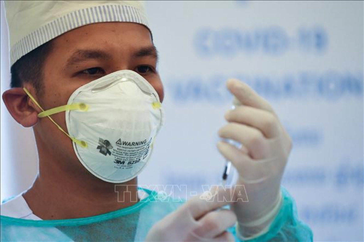 Nhân viên y tế tiêm vaccine ngừa bệnh viêm đường hô hấp cấp COVID-19 cho người dân tại Phnom Penh, Campuchia. (Ảnh: AFP/TTXVN)
