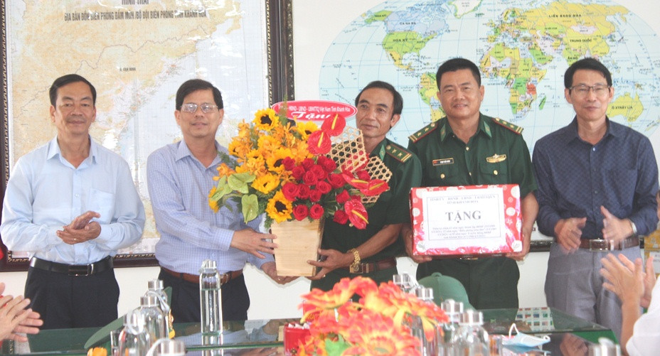 Ông Nguyễn Tấn Tuân và Đinh Văn Thiệu tặng hoa chúc mừng Đồn Biên phòng Đầm Môn.