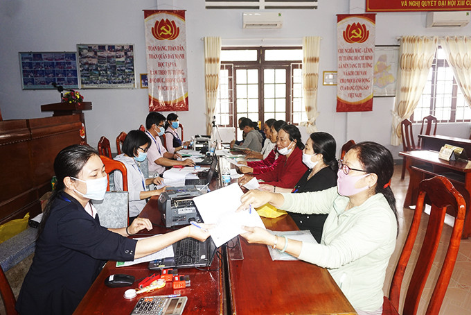 Cán bộ Phòng Giao dịch Ngân hàng Chính sách xã hội huyện Diên Khánh  giao dịch tại xã Diên Toàn. Ảnh: K.N