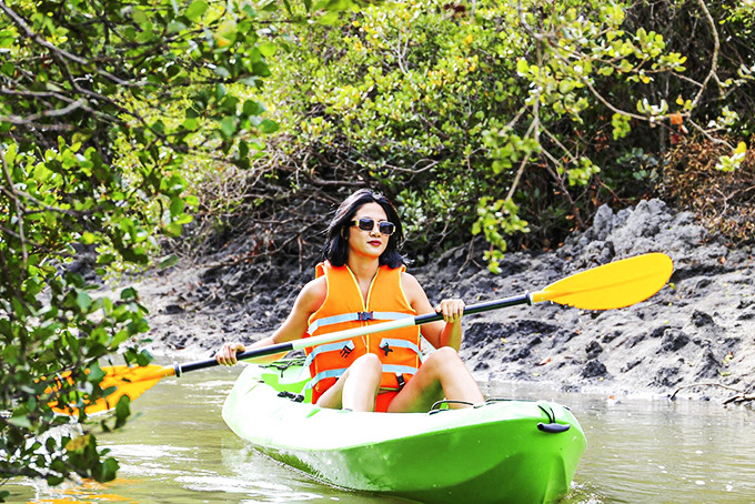 Khách du lịch khám phá rừng ngập mặn bằng thuyền kayak ở Khu du lịch Đảo Hoa Lan. 