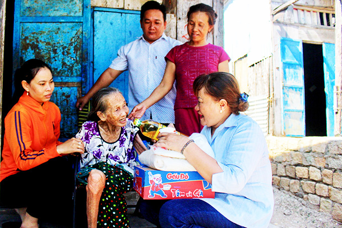 Bà Nguyễn Thị Hoa (bên phải) thăm hỏi, tặng quà cho gia đình bà Nguyễn Thị Bông.