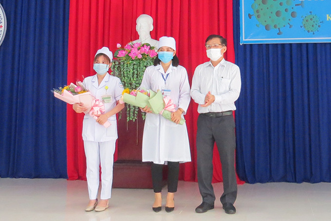 Lãnh đạo Sở Y tế trao tặng hoa cho cán bộ thực hiện tiêm và người được tiêm mũi đầu tiên.